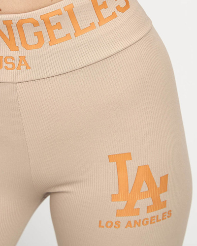 Royalfashion Jasnobrązowe damskie prążkowane legginsy z pomarańczowymi napisami