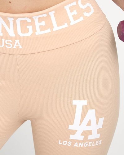 Royalfashion Pudrowe damskie prążkowane legginsy z białymi napisami