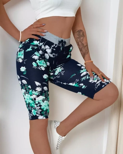 Royalfashion Granatowe spodenki damskie 3/4 w zielone kwiaty PLUS SIZE